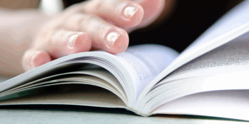 Un livre ouvert avec une main qui lit ce livre (